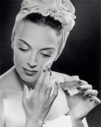Woman applying skin cream, 1945-1955.