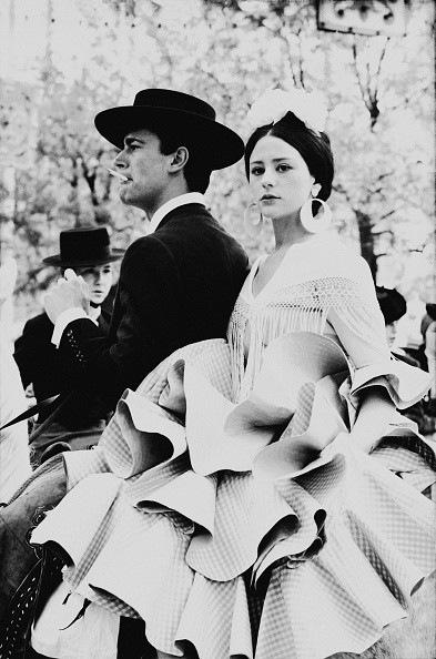 Matias Figares and Soito Figares, wearing a big ruffled skirt, riding horse a la grupa, during the Feria in Sevilla, Spain